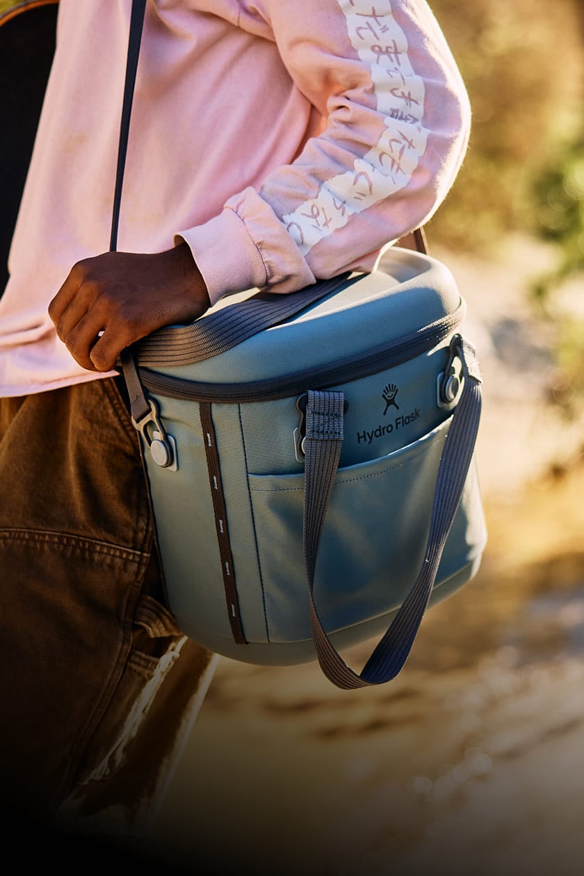 close up of a man holding a hydro flask carryout cooler with a shoulder strap