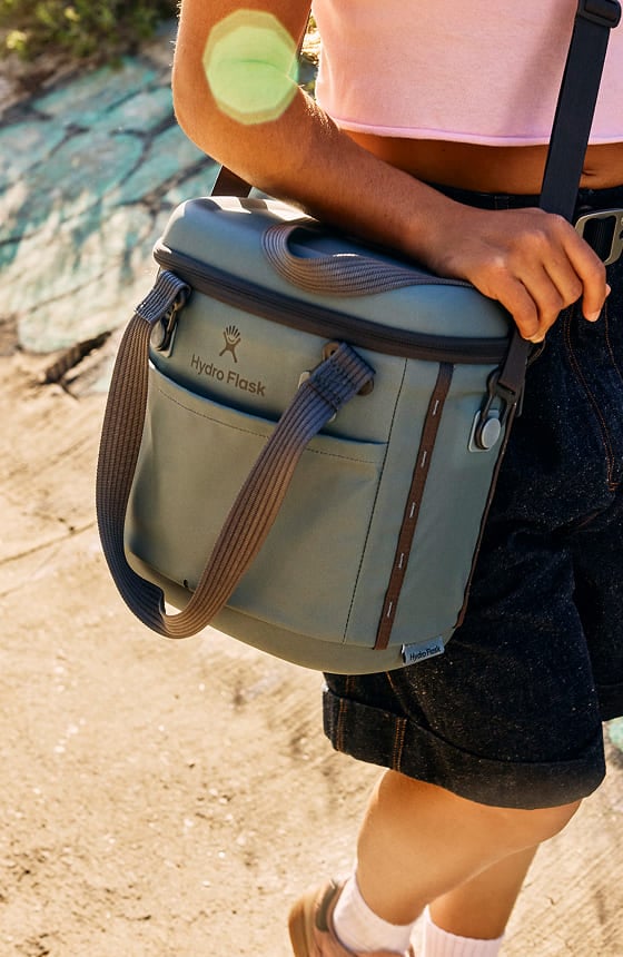 person carrying a hydro flask soft cooler with a shoulder strap