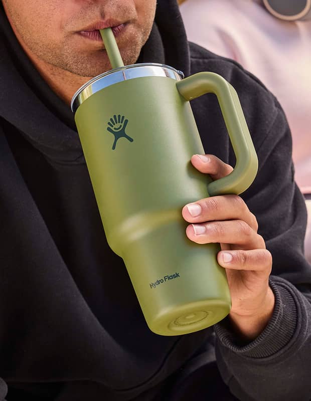 Man drinking out of a Palmer Green Hydro Flask tumbler